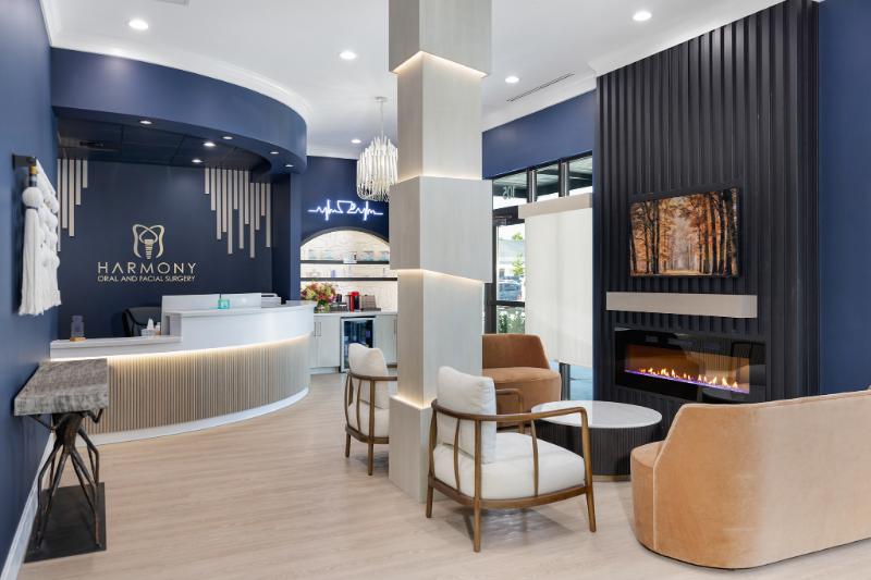 A modern interior space with a reception area featuring a seating arrangement, a fireplace, and a well-lit environment.