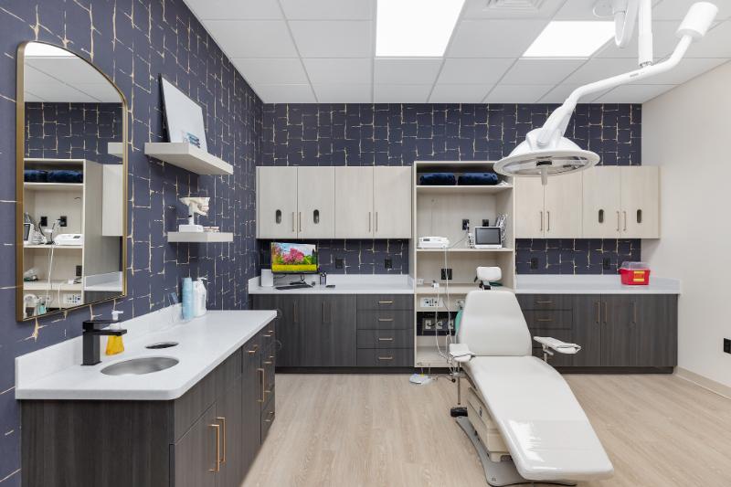 The image shows a well-equipped dental office with modern furnishings and equipment.