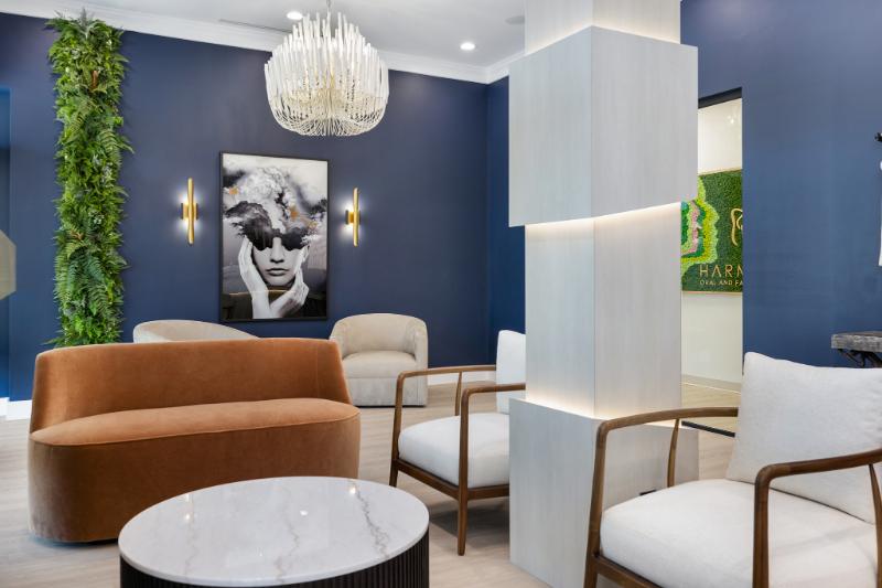 A modern living room with dark walls, white furniture, a chandelier, and contemporary decor.