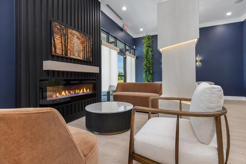 This image shows an interior space with modern furniture and decor, featuring a fireplace, seating area, and contemporary design elements.