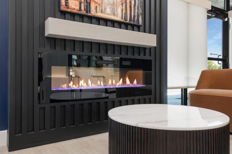 A modern living room with a fireplace, marble coffee table, and contemporary decor.