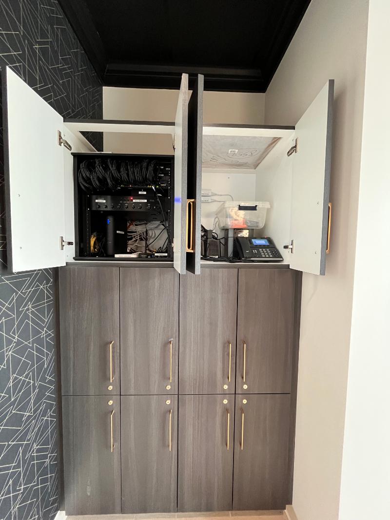 The image depicts a kitchen with white cabinets and drawers, featuring a built-in oven and microwave, along with a countertop and various appliances.
